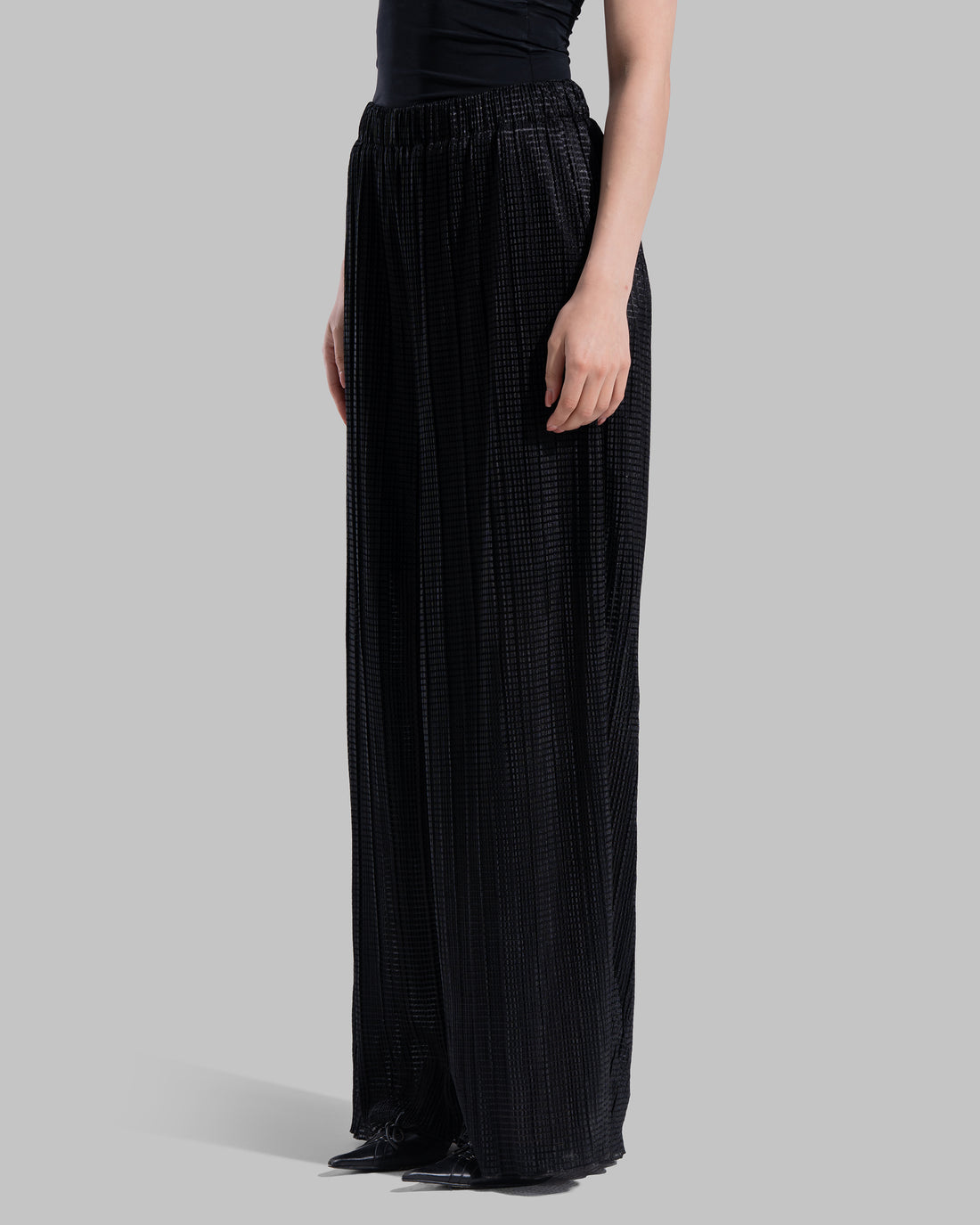 High-waisted wide-leg trousers with an elastic waistband and a textured plissé fabric.