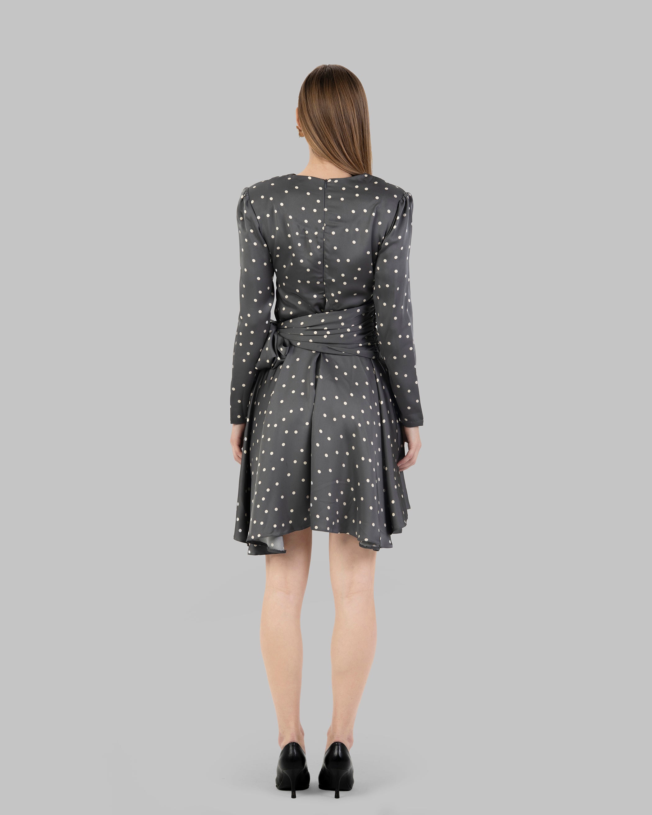 A chic polka dot mini dress with long sleeves and a stylish wrap-around tie waist