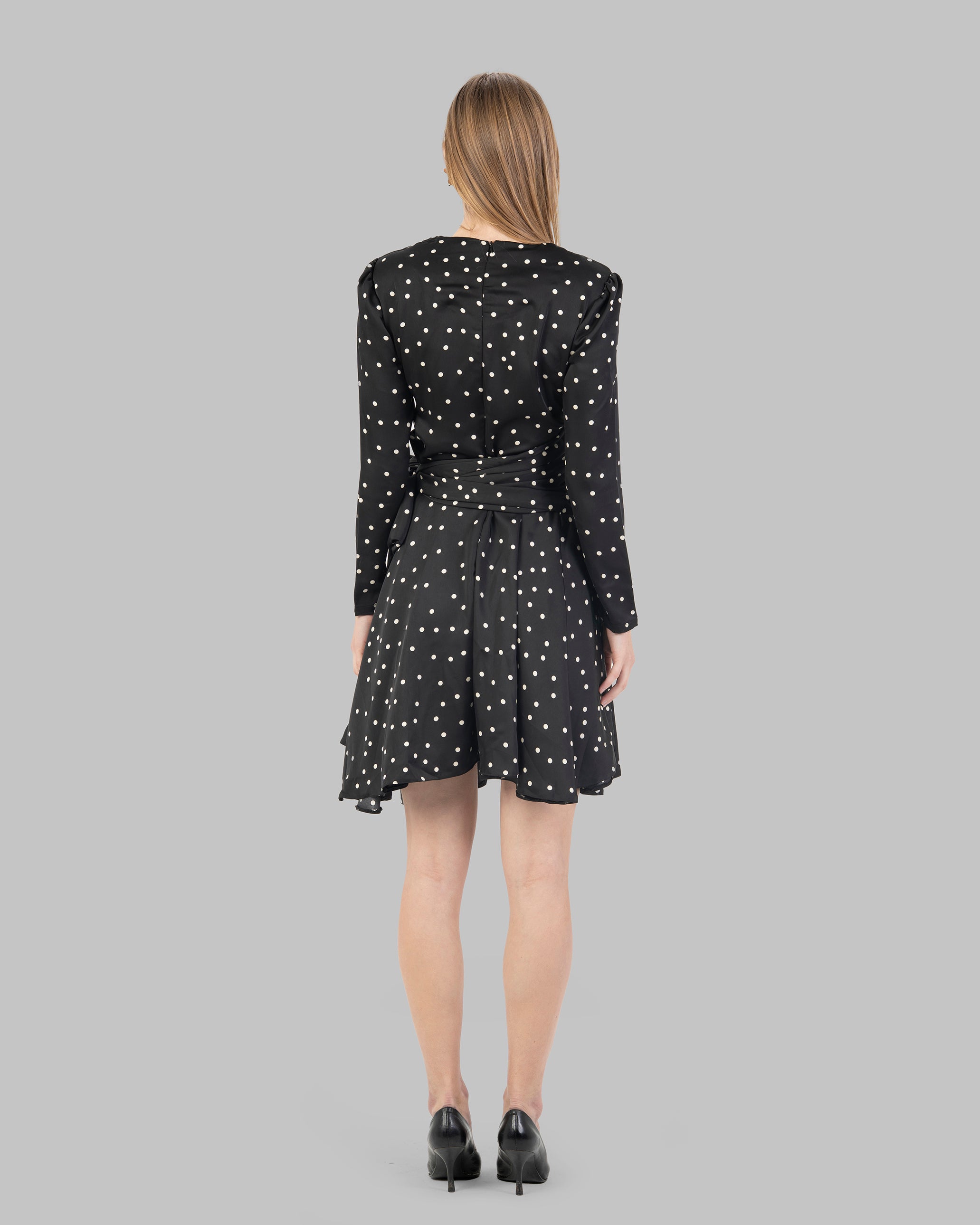 A chic polka dot mini dress with long sleeves and a stylish wrap-around tie waist