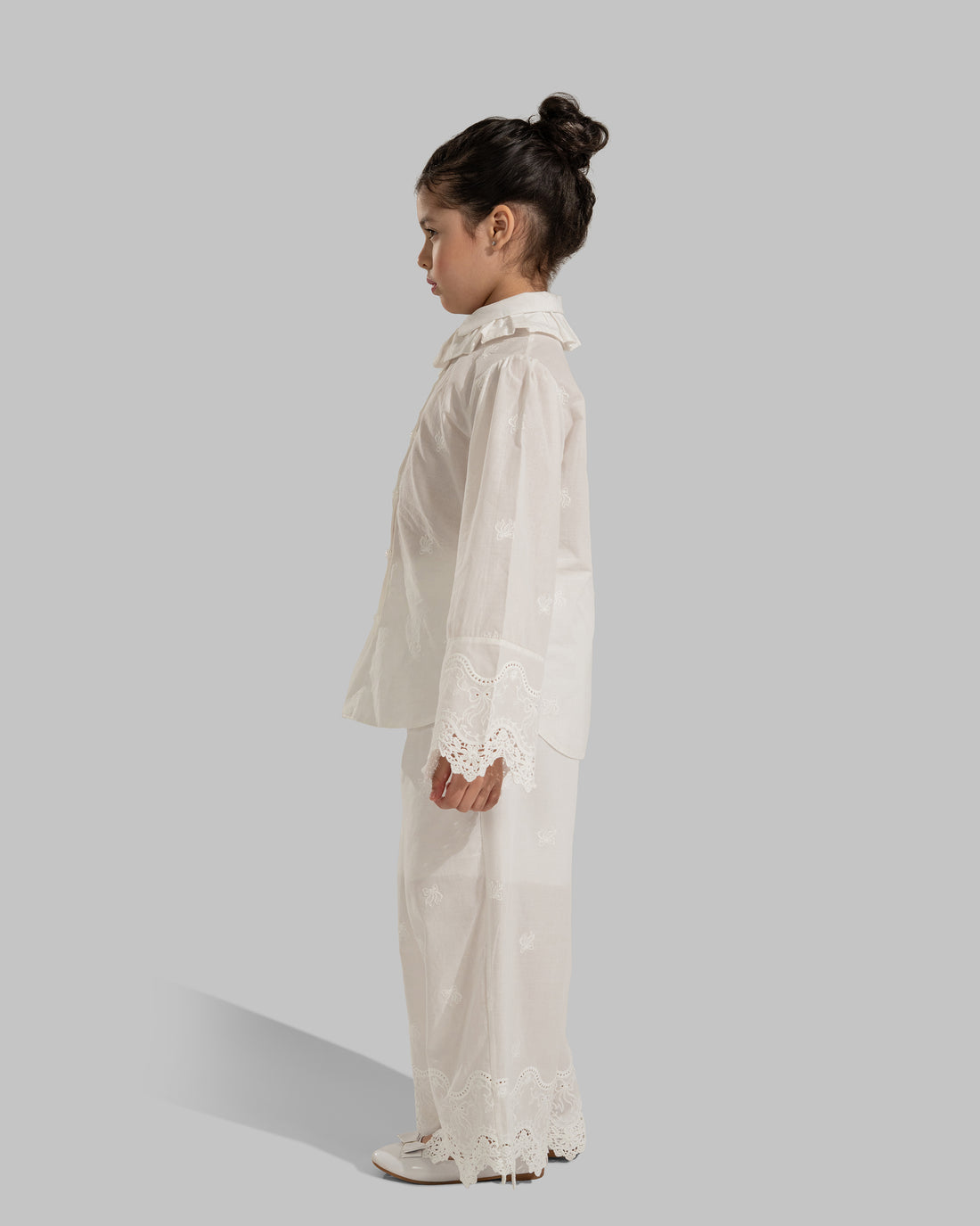 Button-up blouse with a ruffled collar and embroidered lace cuffs.