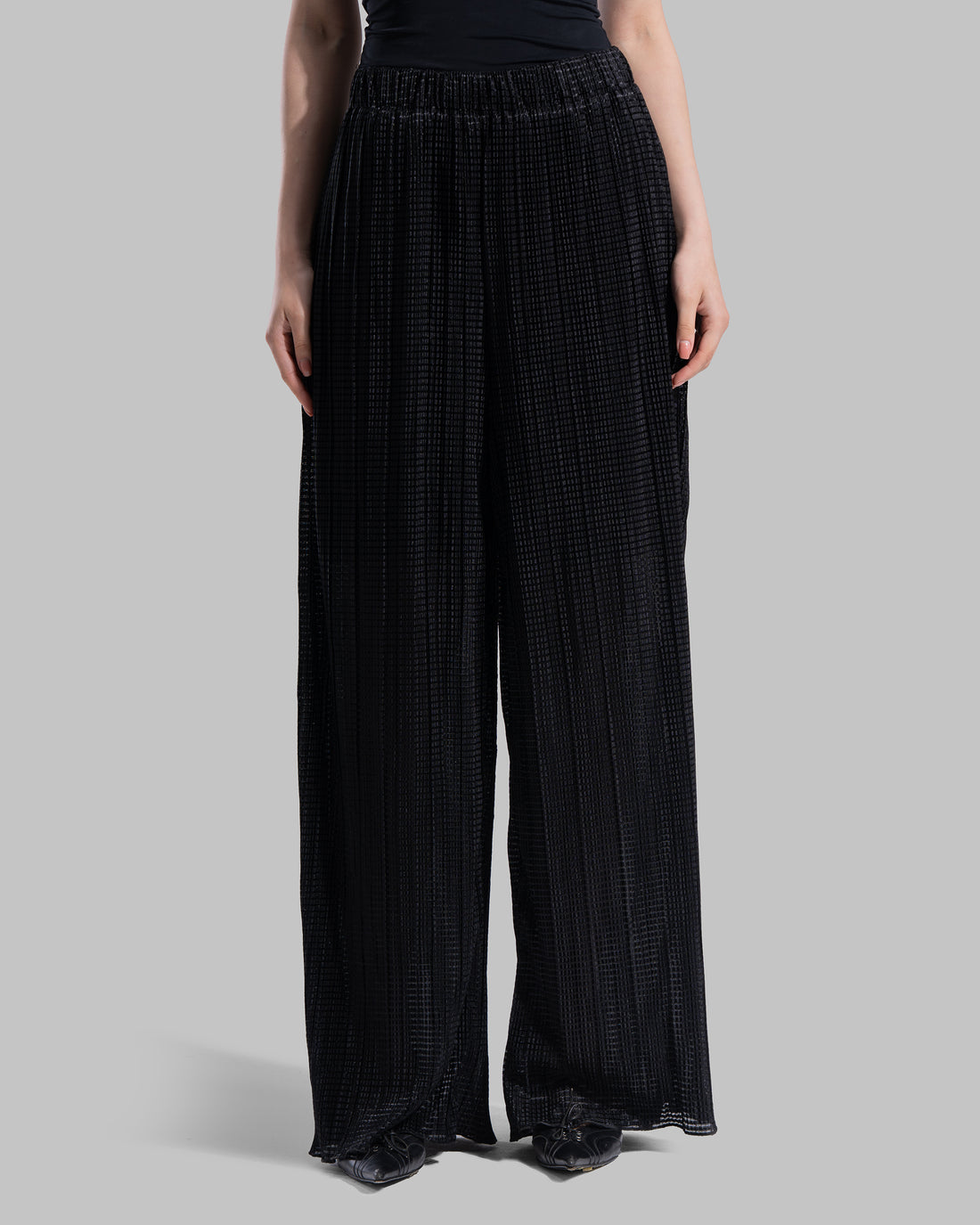 High-waisted wide-leg trousers with an elastic waistband and a textured plissé fabric.