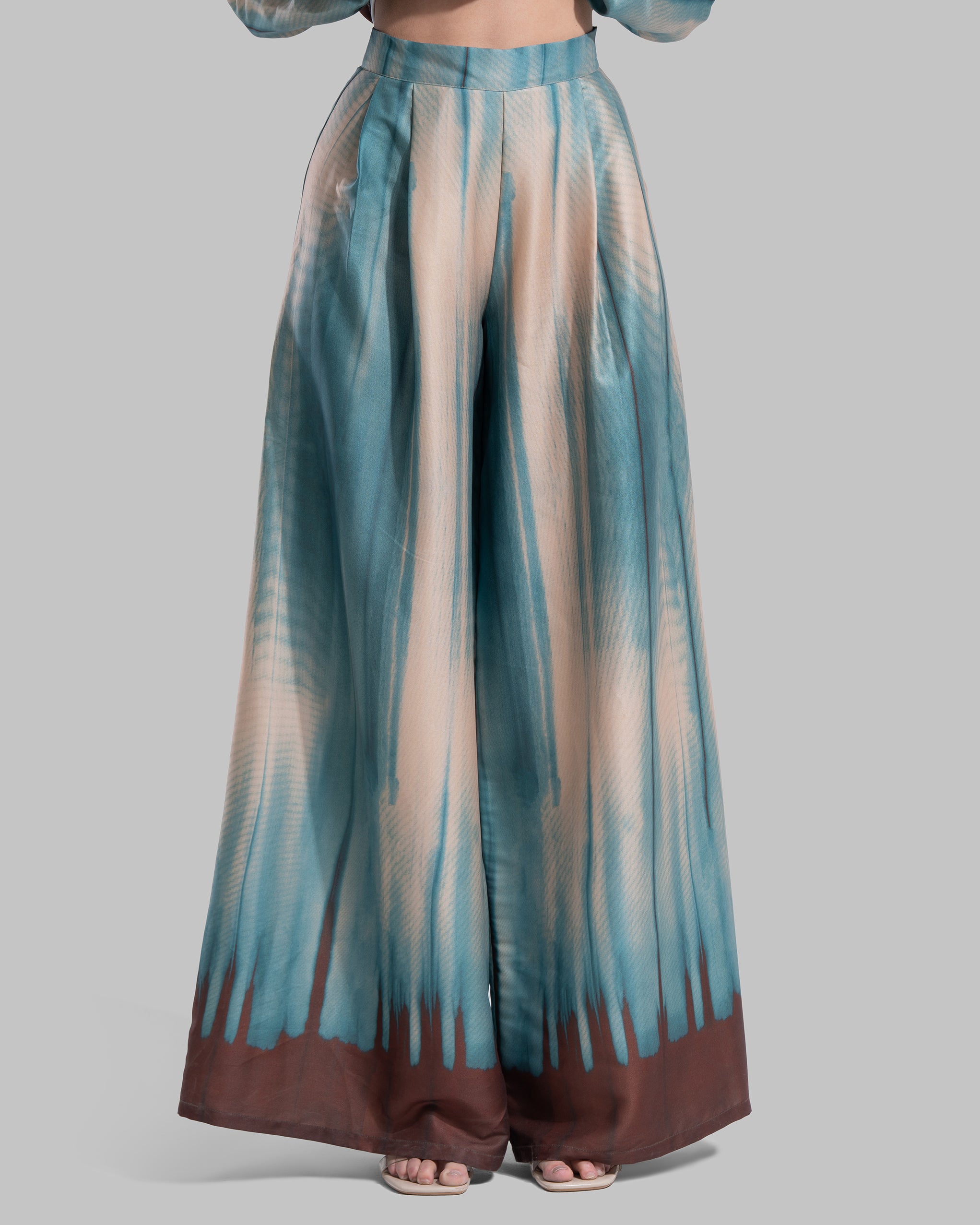 Wide-leg high-waisted trousers in a matching teal and cream abstract gradient pattern.