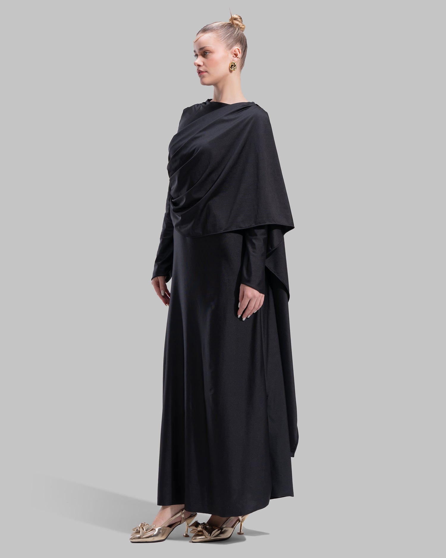 Long draped dress with a round neckline and asymmetrical overlay detail.