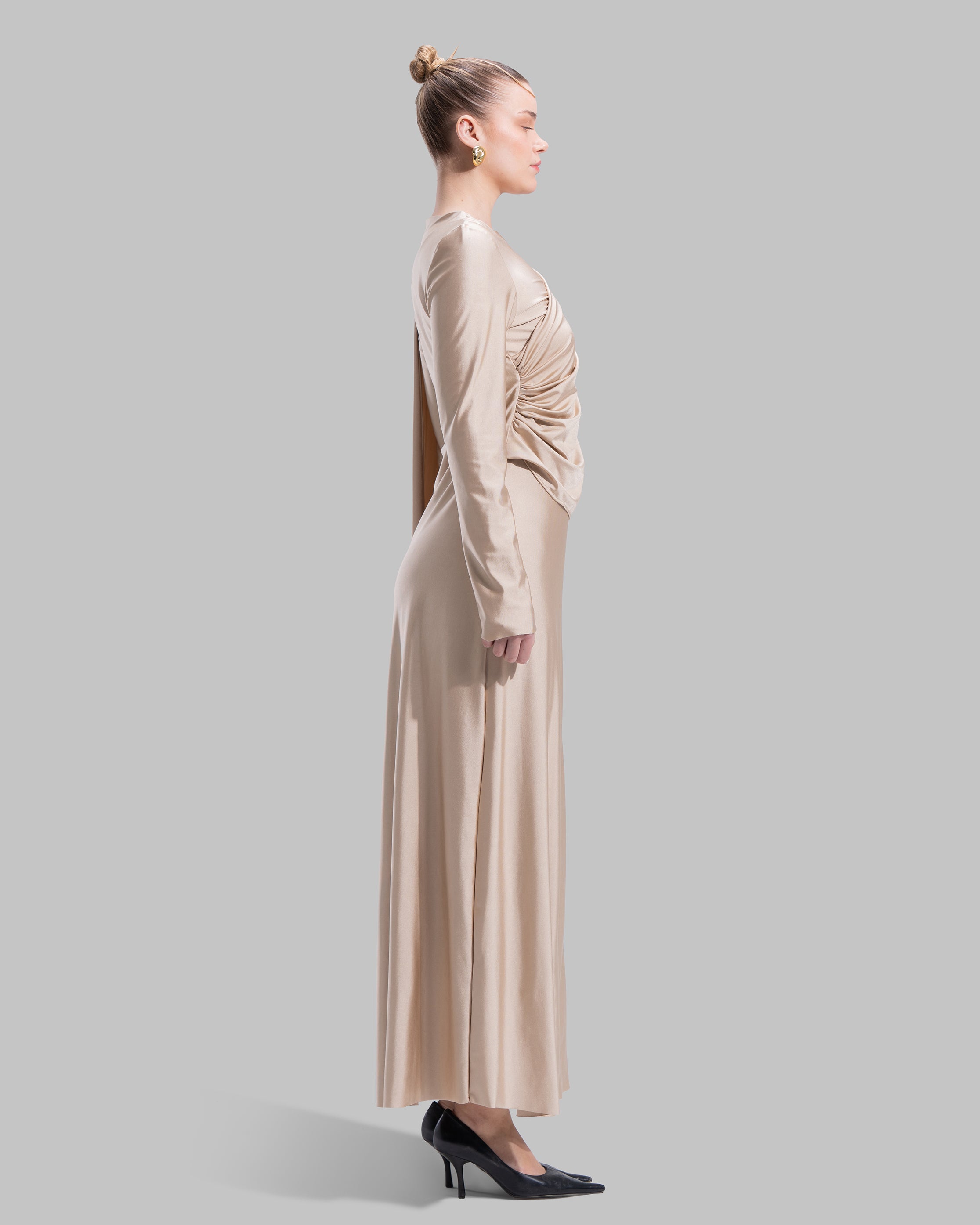 Long draped dress with a round neckline and asymmetrical overlay detail.