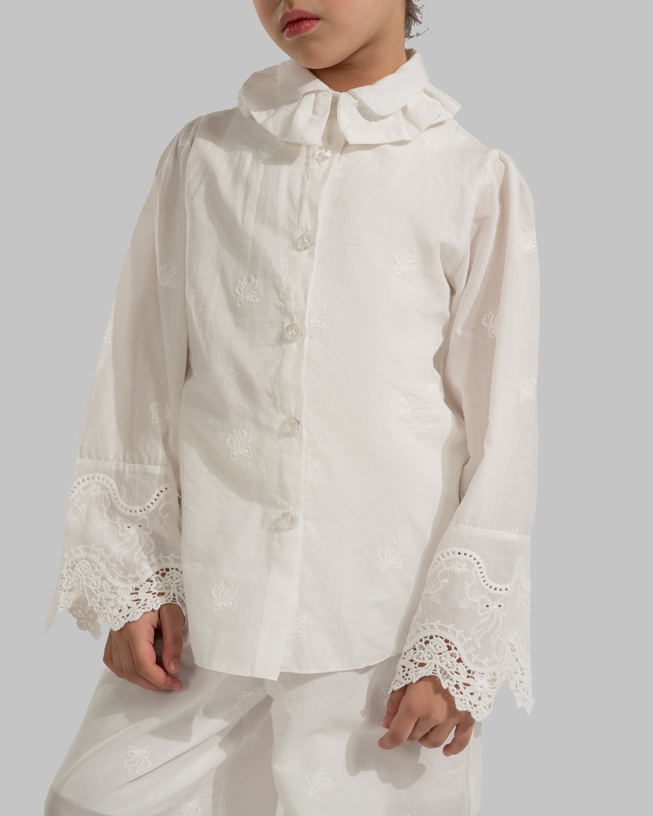 Button-up blouse with a ruffled collar and embroidered lace cuffs.