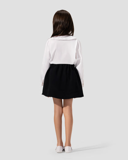 Short pleated skirt in navy blue with gold-tone button detail at the waist